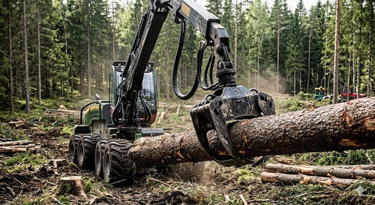 Forestry machine using a hydraulic rotator and grapple to maneuver a large log.