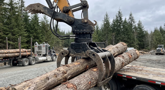 An image of a large log grapple attached to an excavator arm, with a black, multi-hose Hydraulic Rotator prominent at the joint. The grapple is holding heavy logs